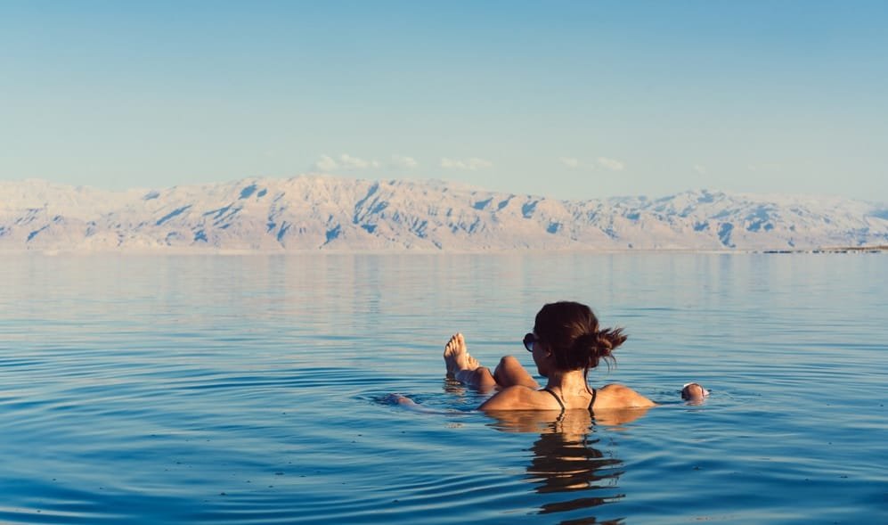 Girl is relaxing and swimming in the water of the Dead Sea in Israel